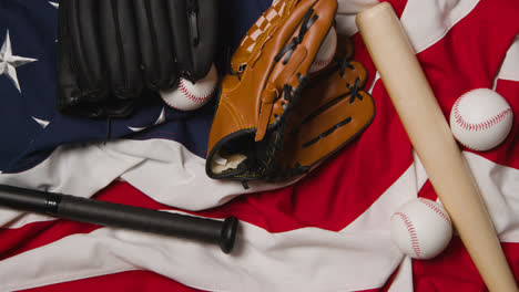 Baseball-Stillleben-über-Dem-Kopf-Mit-Fängerhandschuh-Auf-Amerikanischer-Flagge,-Während-Schläger-Und-Ball-In-Den-Rahmen-Geworfen-Werden